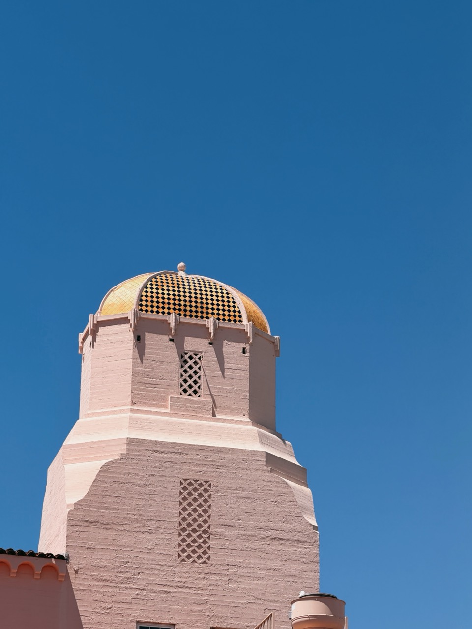 A pink tiled tower against a blue sky